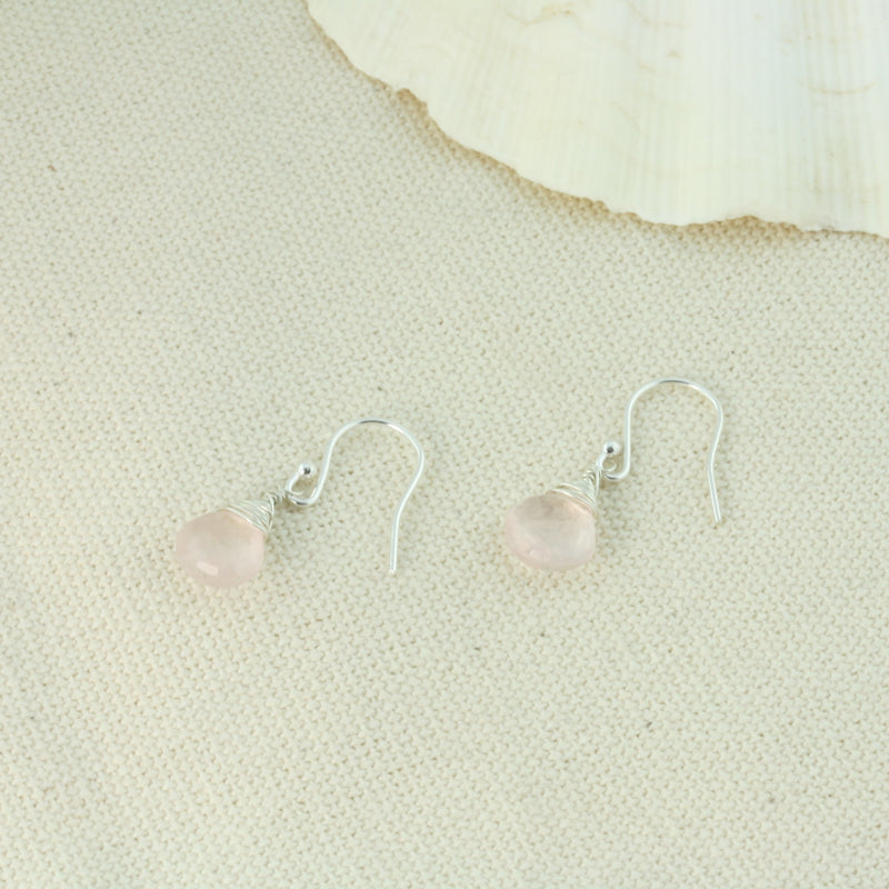 Silver briolette earrings featuring Rose Quartz faceted teardrop gemstones. The facets point at different angles catching the light perfectly for a bit shimmer and shine. They are wrapped with eco silver wire and dangle from silver earrings hooks.