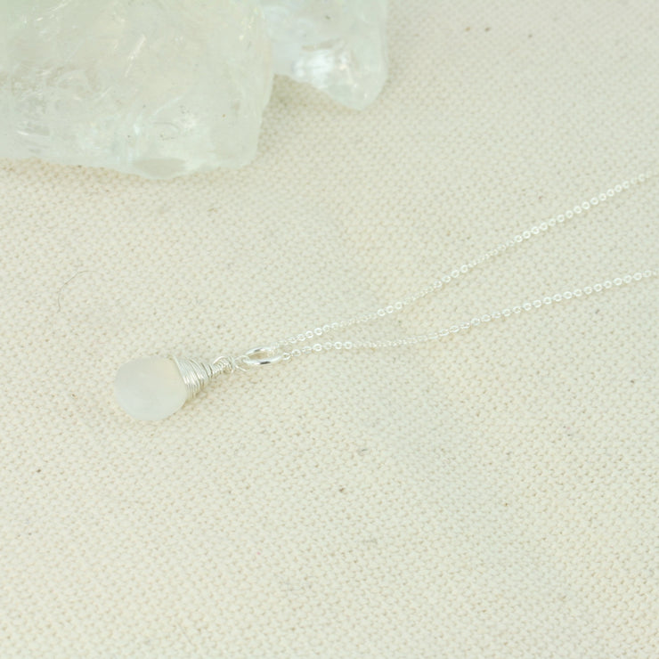 Silver briolette pendant necklace featuring a White Moonstone faceted teardrop gemstone. The facets point at different angles catching the light perfectly for a bit shimmer and shine. It is wrapped with eco silver wire and dangles from a delicate silver necklace.