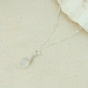Silver briolette pendant necklace featuring a White Moonstone faceted teardrop gemstone. The facets point at different angles catching the light perfectly for a bit shimmer and shine. It is wrapped with eco silver wire and dangles from a delicate silver necklace.