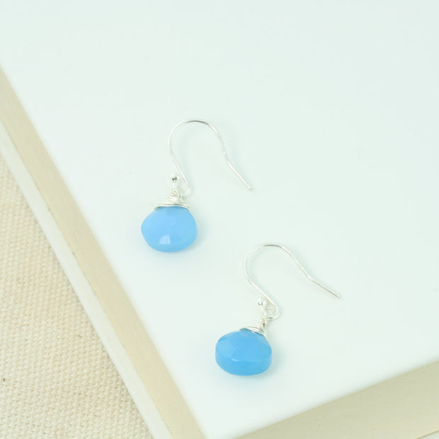 Silver briolette earrings featuring Blue Chalcedony faceted heart gemstones. The facets point at different angles catching the light perfectly for a bit shimmer and shine. They are wrapped with eco silver wire and dangle from silver earrings hooks.