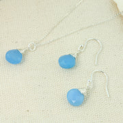 Silver briolette earrings featuring Blue Chalcedony faceted heart gemstones. The facets point at different angles catching the light perfectly for a bit shimmer and shine. They are wrapped with eco silver wire and dangle from silver earrings hooks. Paired here with the silver briolette pendant necklace with Blue Chalcedony faceted heart gemstone.