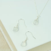 Silver briolette earrings featuring White Moonstone faceted teardrop gemstones. The facets point at different angles catching the light perfectly for a bit shimmer and shine. They are wrapped with eco silver wire and dangle from silver earrings hooks. Paired here with the matching Silver pendant necklace.