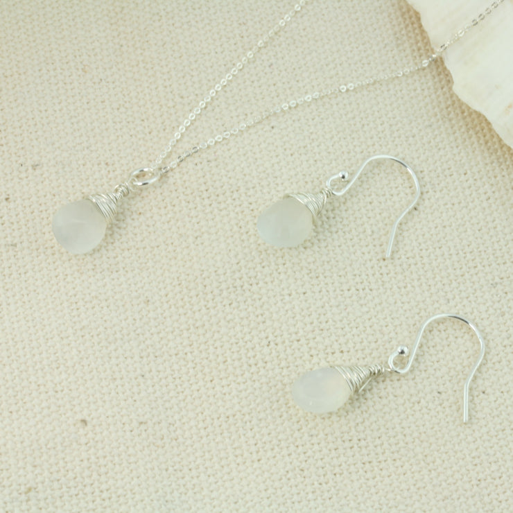 Silver briolette earrings featuring White Moonstone faceted teardrop gemstones. The facets point at different angles catching the light perfectly for a bit shimmer and shine. They are wrapped with eco silver wire and dangle from silver earrings hooks. Paired here with the matching Silver pendant necklace.