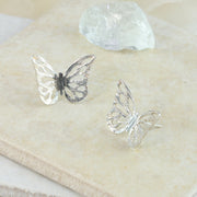 Eco silver butterfly stud earrings. The pattern is sawn out by hand and the striped texture and shiny finish give these butterflies a shimmering finish. The body has a darker oxidised finish.
