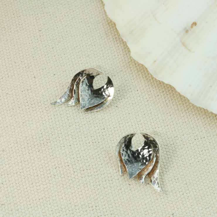 Silver domed petal stud earrings that have been slightly domed and textured. The heart of the petal has a darker oxidised finish. The stud earrings have a shiny finish.