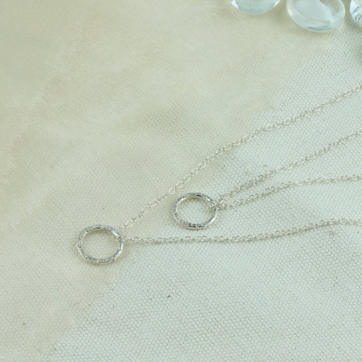 Silver double hoop multi strand necklace. Both hoops have a hammered shiny finish to let the light bounce of and give them a sparkly finish.