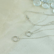 Silver double hoop multi strand necklace. Both hoops have a hammered shiny finish to let the light bounce of and give them a sparkly finish.
