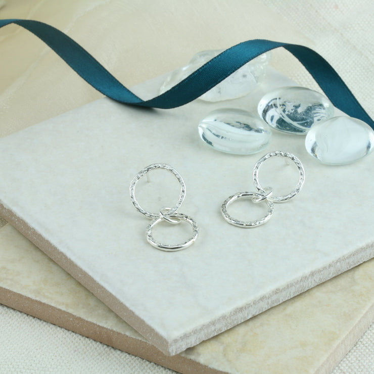 Double hoop stud earrings with a hammered textured finish. The texture creates angles for the light to sparkle from.