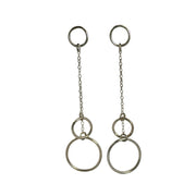 Silver drop earrings featuring two smaller hoops and one larger hoop. One smaller hoop is the stud earring to which the other two hoops are attached. They're attached with a jump ring which holds two chains in place to which the two hoops are attached. The smaller one sits above the larger hoop.