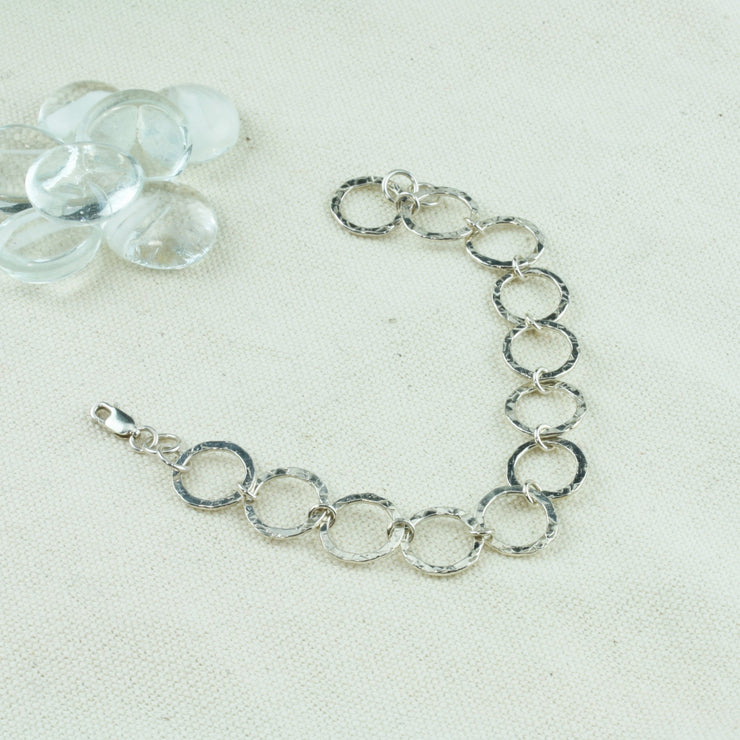 Silver hoop bracelet with a hammered texture for added sparkle.