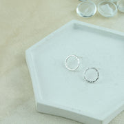 Silver shiny hoop stud earrings, flat hoops with a hammered and shiny finish. 