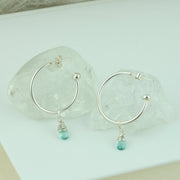 Silver hoop earrings with briolette gemstones. Classic hoop earrings, featuring a shiny polished finish. Featured here with Ocean Apatite briolette gemstones.