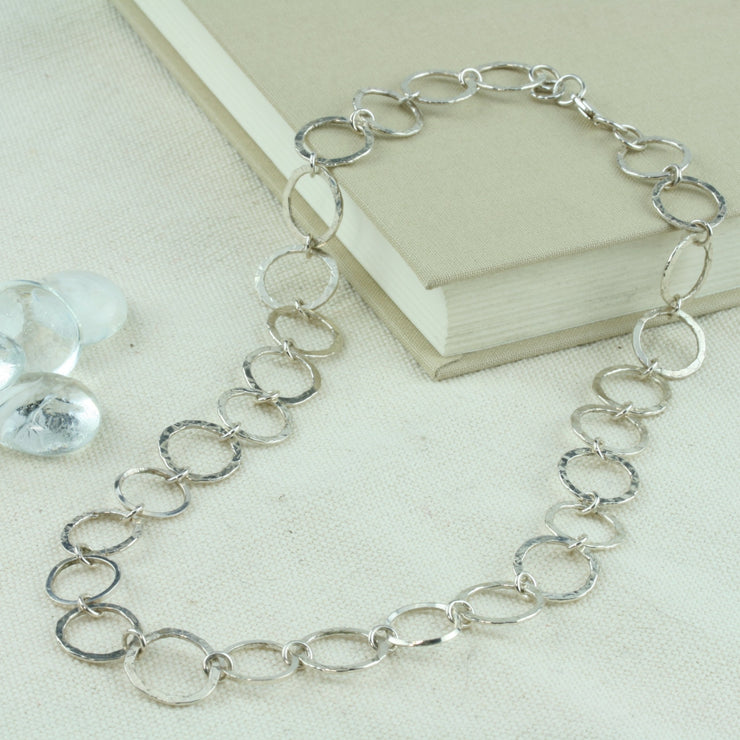 Silver hoop necklace with hammered hoops that sparkle in the light. Four hoops in the middle are made from square silver wire.