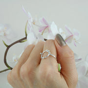 Eco silver ring featuring a square ring band and a round hoop. Spread around the hoop are 6 silver balls to add a fun fresh touch to the ring. It has a shiny mirror finish.
