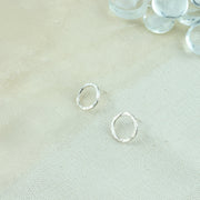 Silver shiny hoop stud earrings, flat hoops with a hammered and shiny finish.