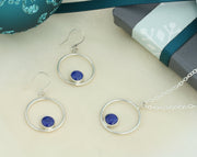 Silver pendant necklace featuring a hoop with a gemstone in inside at the bottom. The gemstone measures 8mm in diameter. This pendant features a Lapis Lazul cabochon gemstone, other options are available. Shown here with the matching earrings.