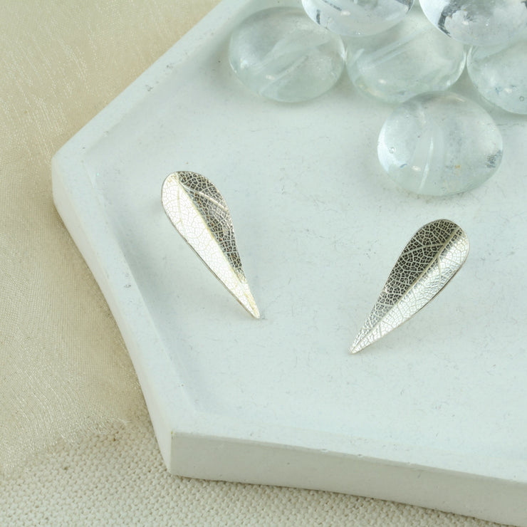 Eco silver leaf stud earrings. The leaves have a slight bend in the middle and have a real leaf texture. The texture adds sparkle to the leaf as it captures the light.