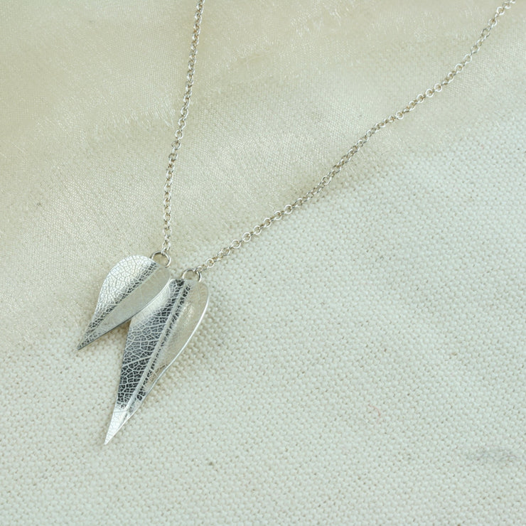 Eco silver necklace featuring two different sized leaves which have given a real leaf texture. The smaller leaf sits a little in front of the larger leaf. The back of the leaves have a shiny mirror finish.