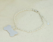 Silver personalised charm bracelet with a dog bone charm that can be personalised with a word, name, initials or symbols of your choosing. The bracelet features an extender chain so the bracelet fits between 16.5 and 21cm. The charm is made using eco silver.