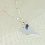 Silver personalised heart pendant necklace with Amethyst briolette gemstone.  The heart is approximately 2.5 x 2cm in diameter  with a smaller version of 2 x 1.5cm available as well and can be personalised with a word, initials, letter or symbols. The briolette gemstones is attached to the same jump ring as the pendant, so they sit together. The necklace can be fastened at three different lengths at 40cm, 45cm and 50cm.