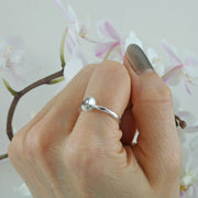 Eco silver cup ring with a 9ct gold ball. The silver ring band features a domed cup with a stripe texture.