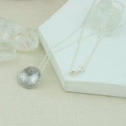 Eco silver pendant necklace with a pebble texture.