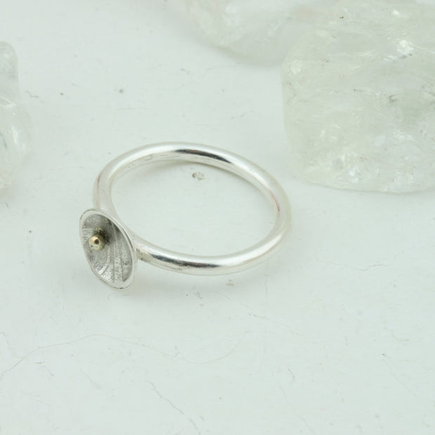 Eco silver cup ring with a 9ct gold ball. The silver ring band features a domed cup with a pebble texture.