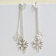 Silver snowflake earrings featuring a stud earring which can be worn on its own. The drop part can be added by looping the stud through the jump ring which features four chains, of which two have a snowflake attached at the bottom. One is larger than the other. The total length of the drop is 10cm / 4". Seen here in combination with the silver snowflake pendant necklace.
