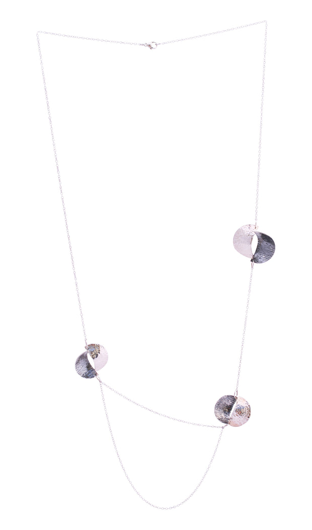 Silver statement opera necklace with 3 split circles, the two lower split circles are connected by two chains creating a drop effect. The  circles are split in half and domed, then soldered together in opposite directions. Both sides have a different hammered texture, one half has a shiny mirror finish, the other an oxidised buffed finish.