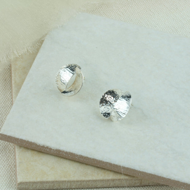 Silver stud earrings featuring two split circles. They are domed circles split in half and soldered together with the domes pointing in opposite directions. Available in a mirror finish, an oxidised darker finish and a combination of the two.