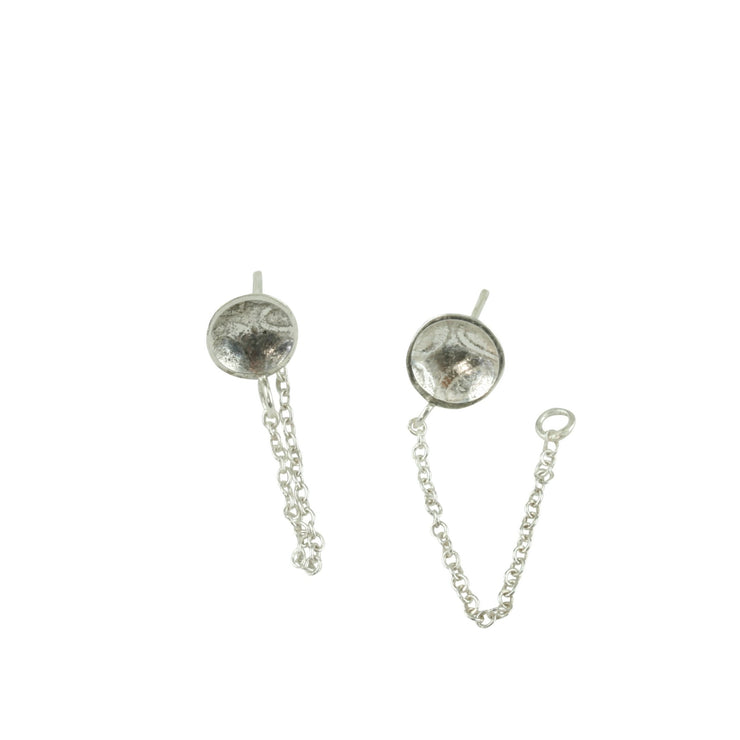 Eco silver small domed cups with a stripe texture. A chain is attached to the cup with a jump ring at the bottom. A jump ring is attached to the end of the chain to loop the stud through and fasten behind it with the silver scroll. These cups have a pebble texture.
