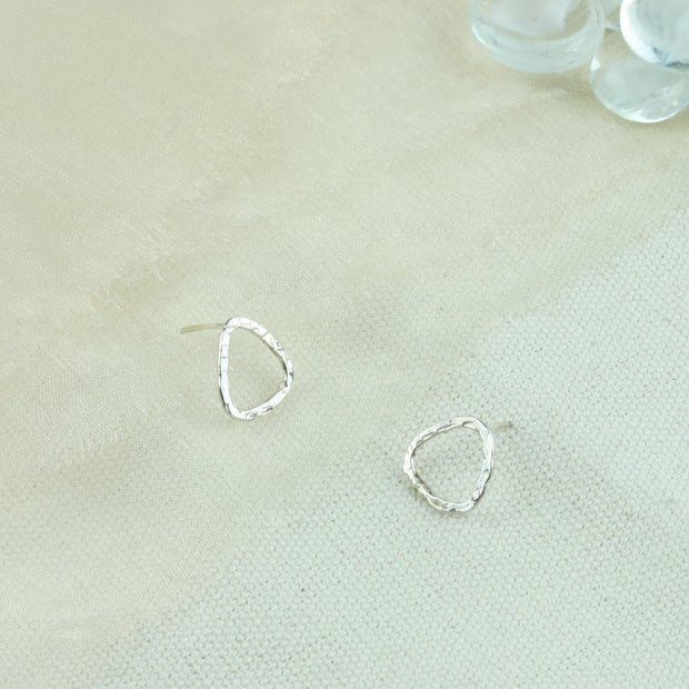 Silver triangle stud earrings with a hammered texture and shiny finish. Sparkling from every angle. 