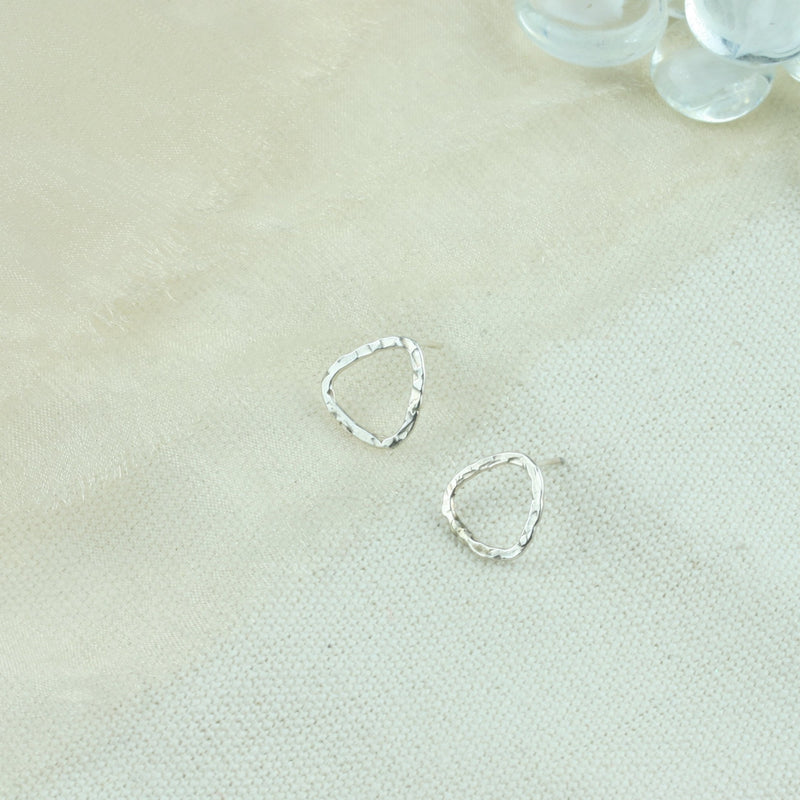 Silver triangle stud earrings with a hammered texture and shiny finish. Sparkling from every angle. 