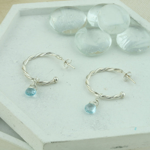 Silver hoop earrings featuring two twisted wires, with briolette gemstones. Classic hoop earrings, featuring a shiny polished finish. Shown here on combined with the London Blue Topaz briolette gemstones. Separate gemstones to add to your collection are available as well.