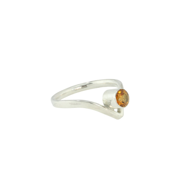 Silver wishbone ring with a Citrine gemstone added to the inside of the dip. The wishbone ring is made from D shaped eco silver wire, with the curve on the inside of the ring band. The wishbone ring is a classic design with a v shaped curve on one side. The curve goes down and the gemstone sits in the curve. This ring features a Citrine gemstone 5mm in diameter set in a tube setting.