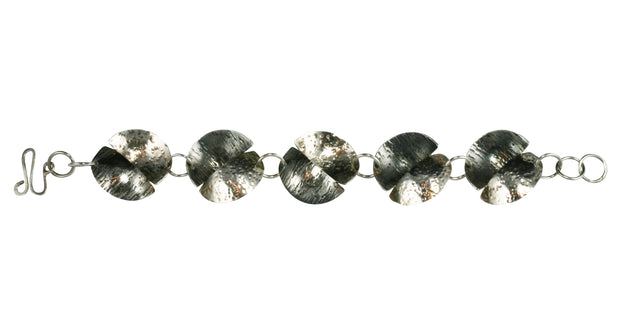 This handmade silver bracelet features 5 split circles and is 20cm long. The circles have been sawn in half, domed and soldered together in opposite directions.  They are approximately 2.5cm in diameter and have a hammered textured finish.  One half is oxidised and looks darker than the other.