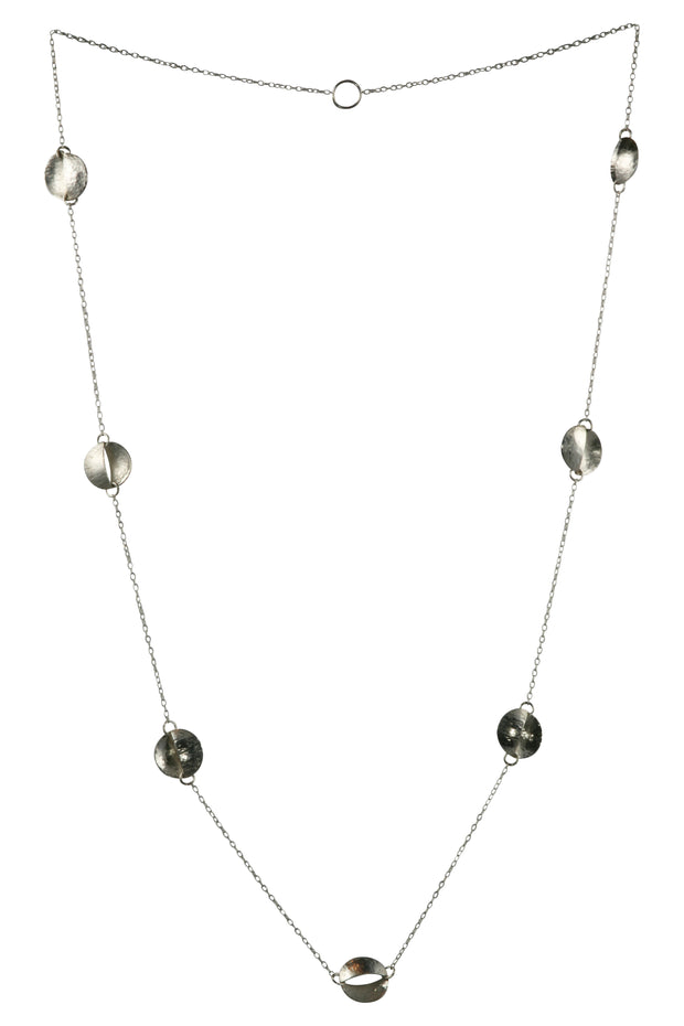 Silver split circle opera necklace with seven split circles. The circles have been san in half and domed and soldered together pointing in opposite sides. One has a round texture, the other a striped texture. One side also has amirror finish and the other an oxidised darker finish.