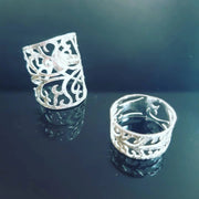 Eco silver Tree of life statement ring. A unique hand drawn and hand sawn Tree of life design in an oval shaped ring. It has a hammered texture and a shiny mirror finish. Also a Tree of life ring band with an altered design and the same hammered and mirror finish.