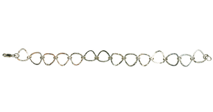 Silver triangle bracelet, featuring triangle shaped links attached to each other with round jump rings. The triangles have a hammered finish to give the triangles a shimmery look. It&