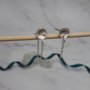 Eco silver small domed cups with a stripe or pebble texture and 9ct gold ball. A chain is attached to the cup with a jump ring at the bottom. A jump ring is attached to the end of the chain to loop the stud through and fasten behind it with the silver scroll. These cups have a stripe or pebble texture and feature gold ball.